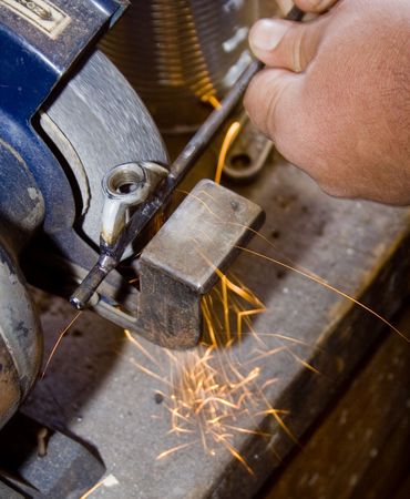 man grinding metal rod with sparks flyingの写真素材