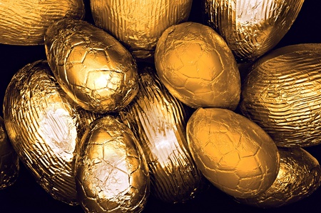 variety easter eggs wrapped in gold shiny foil  on black backgroundの写真素材