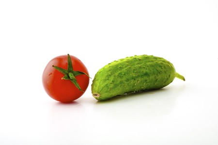 Ripe tomatoes on a branch and cucumber on a white backgroundの写真素材