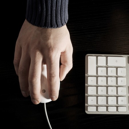 The man's hand works with the white mouseの写真素材