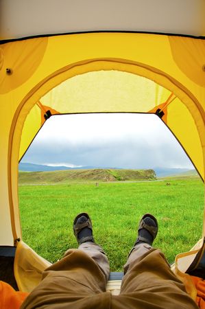 Man lying in tent with a view of mountainの写真素材