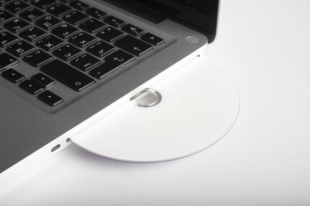 Laptop and CD on background