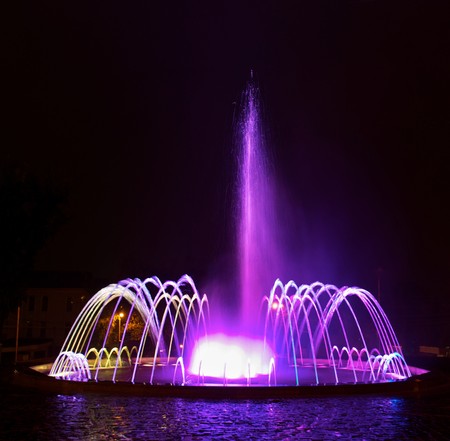 Colored water fountain at nightの写真素材