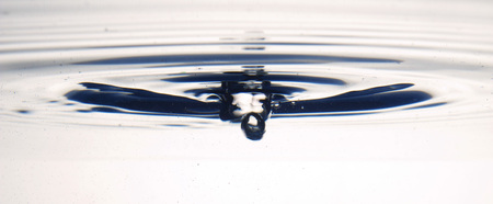 The round transparent drop of water, falls downwards