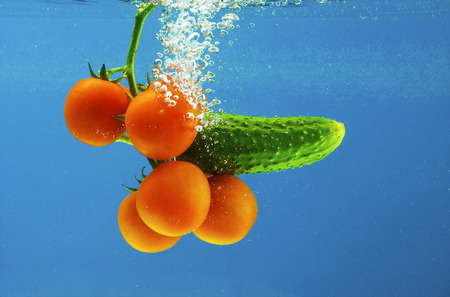A series, vegetables in water on a dark blue backgroundの写真素材