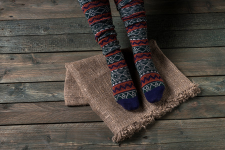 Legs in color socks on a wooden floor