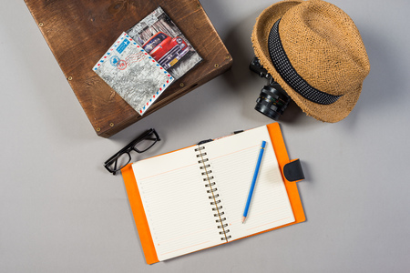 Packed suitcase of vacation items on wooden background.