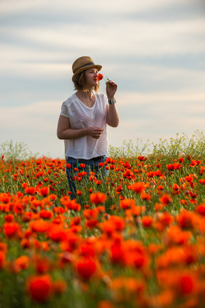 Portrait of young girl in poppy flowers fieldの写真素材