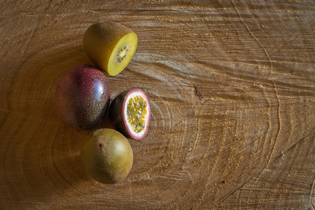 Juicy of passion fruit  and kiwi on a wooden backgroundの写真素材