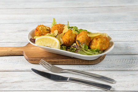 Arancini Balls are Italian rice balls made with cooked risotto rice mixed with cheese, usually mozzarella, and sometimes filled with ingredients like meat, vegetables, or mushroomsの写真素材
