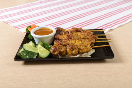 A plate of meat with a sauce and vegetablesの写真素材