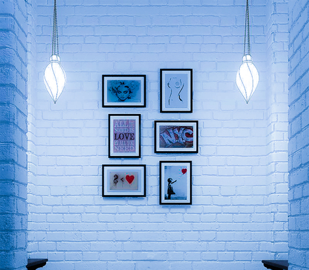 Exhibition of paintings on a white brick wall backgroundの写真素材