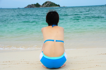 Beautiful young asian woman relaxing at pristine beachの写真素材