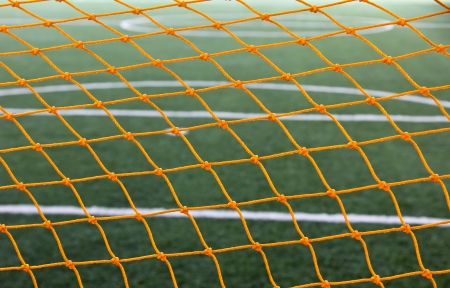 Green artificial grass soccer field for background