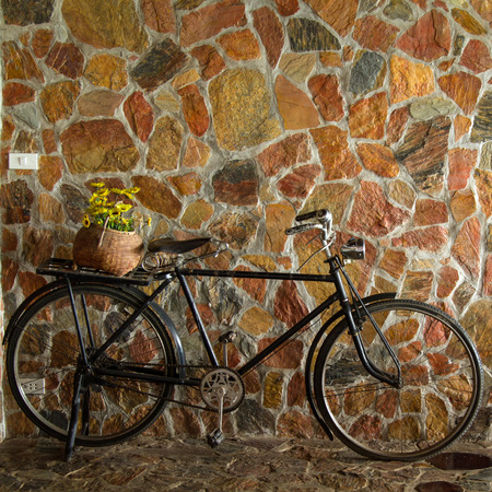 Vintage bicycle leaning against stone brick wallの写真素材