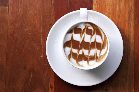 Cup of latte coffee on the wooden deskの写真素材