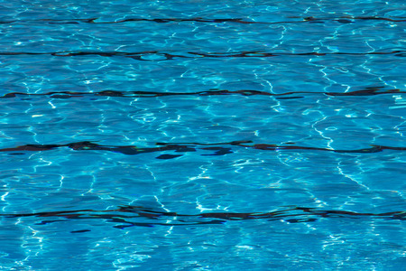 Blue pool water with sun reflections