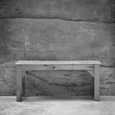 Empty wooden chair with concrete wall background