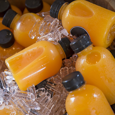 Orange juice bottles on the ice boxの写真素材
