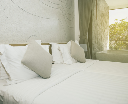 Pillows on bed and lamp in bedroomの写真素材