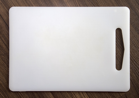 White plastic cutting board on wood backgroundの写真素材