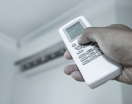 Hand press the button on the remote of the air conditionerの写真素材