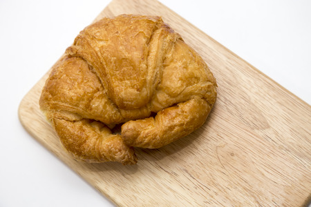 Croissant on wooden background on the tableの写真素材