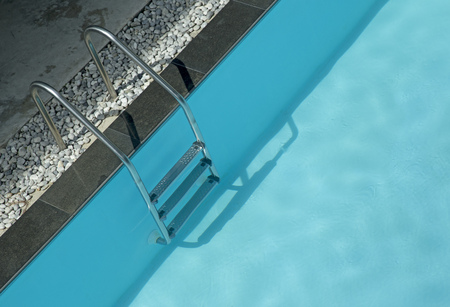 Grab bars ladder in blue swimming poolの写真素材