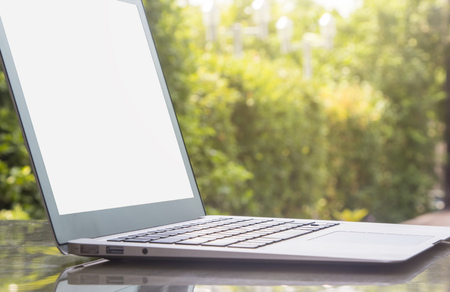 Laptop on stone table with garden backgroundの写真素材