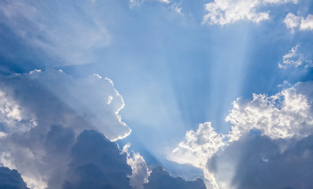 View of clouds in blue sky with rays of lightの写真素材