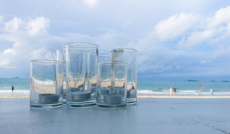 Candle in glass on table with sea backgroundの写真素材