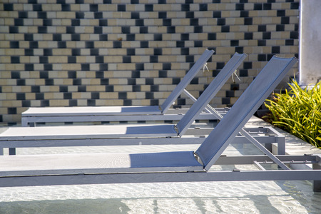 Beach chairs in swimming pool at hotelの写真素材