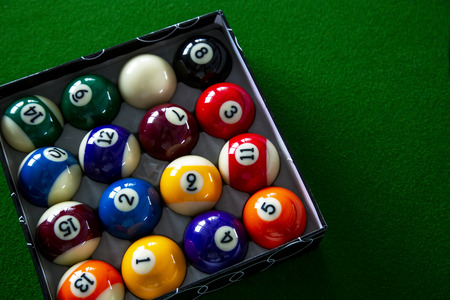Colorful billiard balls in box the on table
