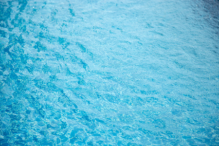 Blue swimming pool reflecting the sun rippledの写真素材