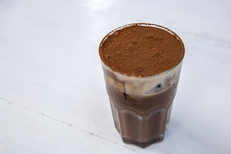 Tiramisu iced coffee with cocoa powder on the tableの写真素材