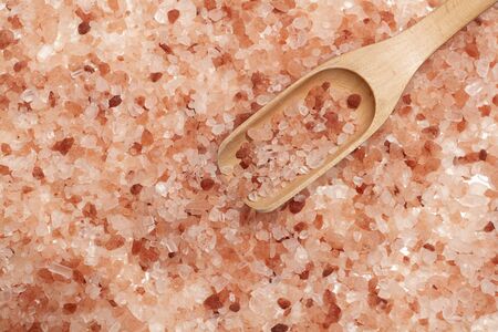 Himalayan pink salt with wooden spoon to scoopの写真素材