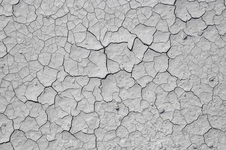 Dried cracked clay texture and gravel stonesの写真素材