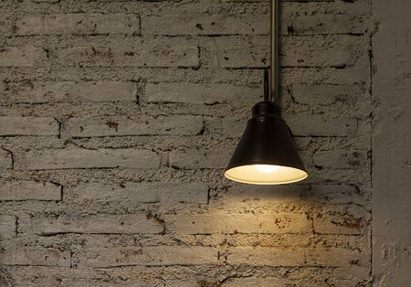 Vintage hang light bulb lamp on brick wall backgroundの写真素材