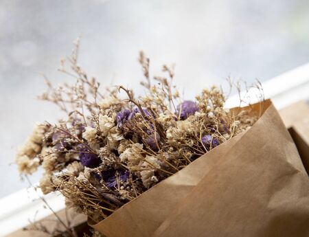 Bouquet of dried flowers in brown paperの写真素材