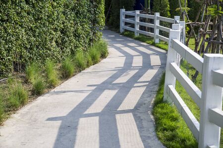 Walkway with white fence in the gardenの写真素材
