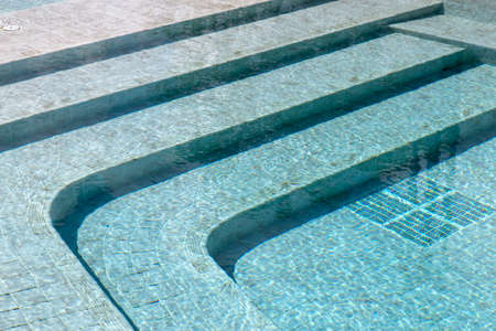 Curved steps at the swimming pool with blue tile mosaicの写真素材