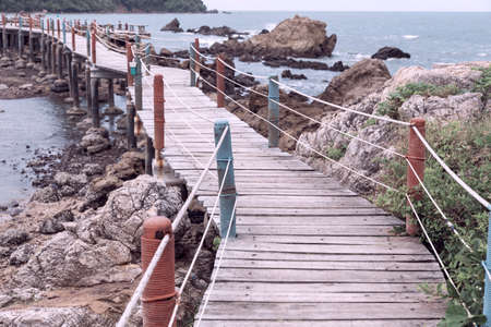 Wooden old bridge boardwalk along on stoneの写真素材