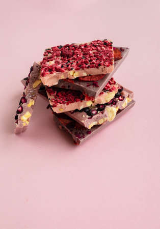 Slices of chokolate bars with nuts and berries with space for textの写真素材
