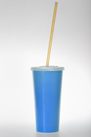 glass of blue paper with a tube on a white backgroundの写真素材