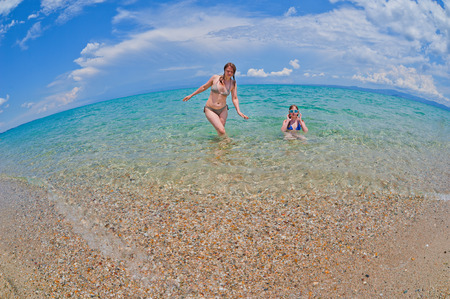 Mother and daughter enjoying time at tropical beachの写真素材