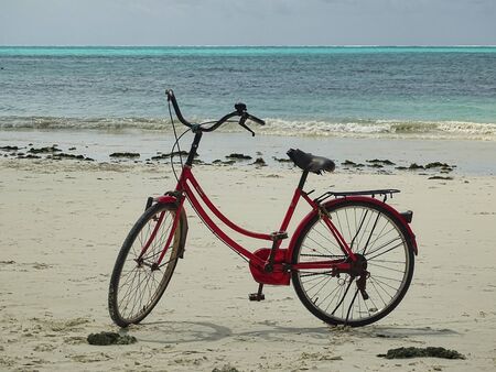 Red bicycle ladies bike on the beach in Africaの写真素材