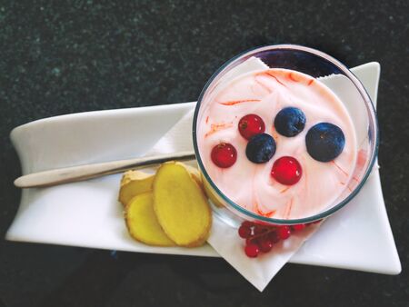 Food trend, dessert, dessert, yogurt in a glass with berries, ginger slices and muesliの写真素材