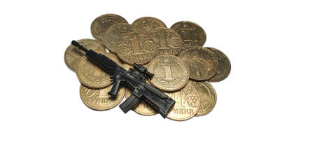 Money to protect Ukraine from aggression. Money for weapons for the army of Ukraine. Many coins in denominations of one Ukrainian hryvnia and a toy automatic rifleの写真素材