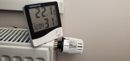 The thermometer is placed on a radiator with a thermostat. Low temperature in dwellings due to...