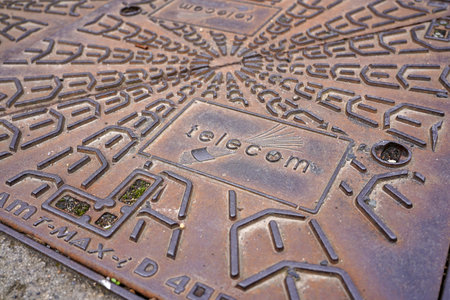 MARCH 17, 2026: THIERS, FRANCE. Close-up of a rusty metal telecom manhole cover.